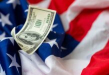 Billion-Dollar Pledge Stuns Parents A hundred dollar bill resting on an American flag
