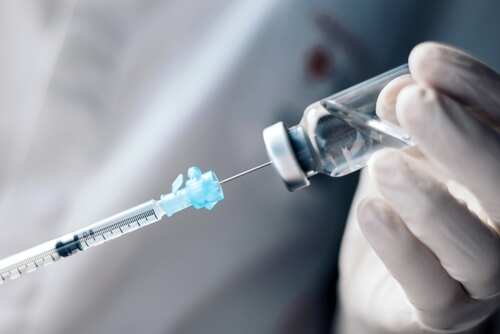 Injecting,Injection,Vaccine,Vaccination,Medicine,Into,A,Syringe,Woman,Nurse A healthcare professional preparing a syringe from a vial