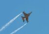 F-16s ROAR Over Rally Fighter jet banking in flight with vapor trails