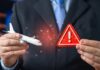 US Issues Travel Warning Upgrade Businessperson holding airplane model and red warning sign