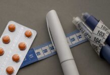 New Weight Drug Stuns Doctors Medication blister pack, insulin pens, and tape measure on a gray surface