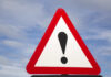 WARNING: 1,670 Detainers Dodged Warning road sign with exclamation mark against a cloudy sky