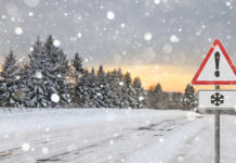 Weather Flip Turns Deadly – Details Snow-covered road with a warning sign and pine trees in the background