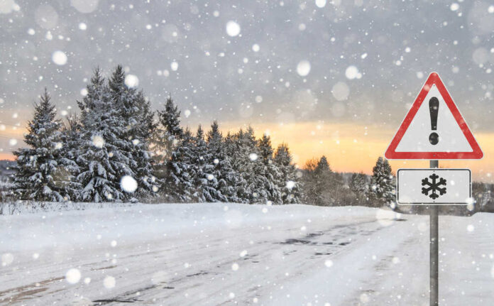 Winter,Road,With,Sign,Snow Snow-covered road with a warning sign and pine trees in the background