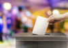 Bold Line Sparks 2028 Buzz Hand placing ballot in voting box.